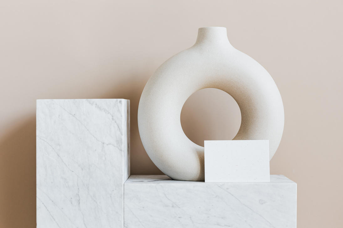 Decorative vase of ring shape with blank card on marble stand